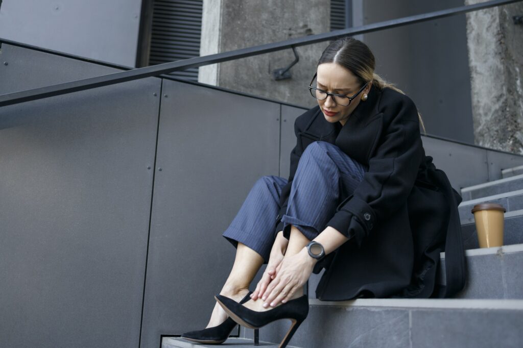 Business woman suffering from pain due to wearing shoes with heels
